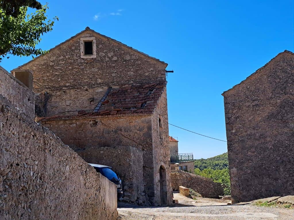 Uska ulica između kamenih kuća u Velom Grablju