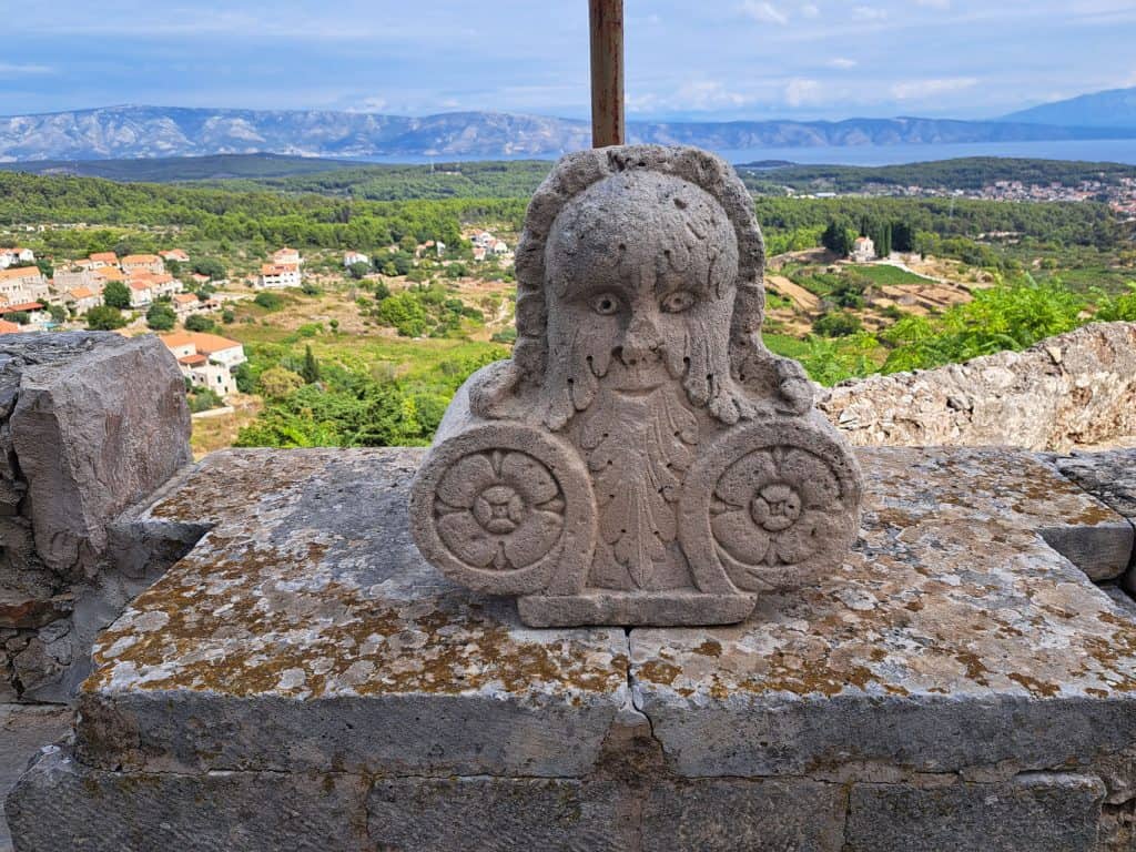 Carved stone relief above Pitve with the Stari Grad plain behind
