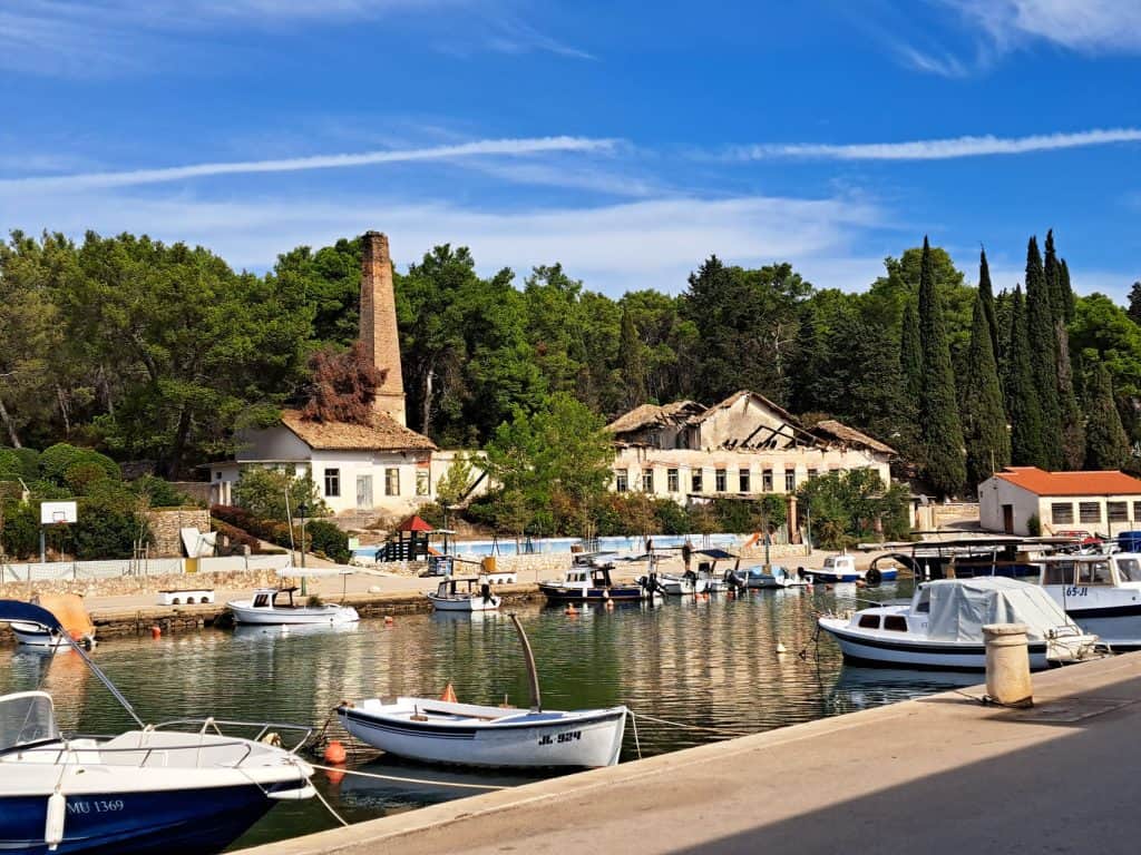 Barke i stari tvornički dimnjak u luci Vrboska