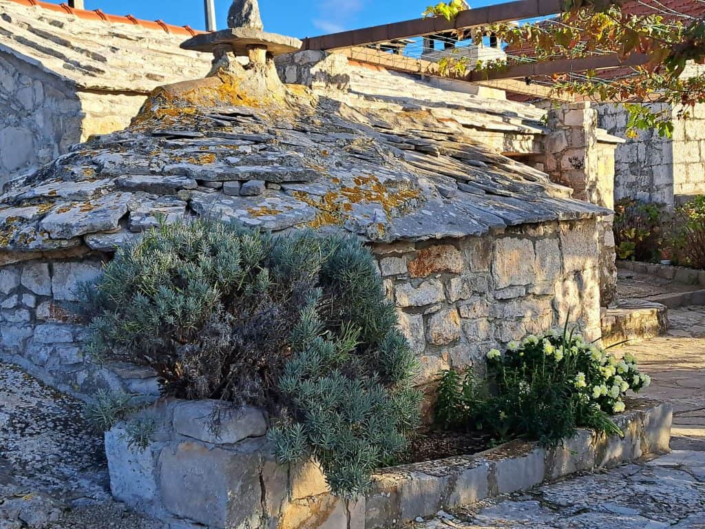 Stone-slab roof and lavender in a courtyard in Selca near Bogomolje