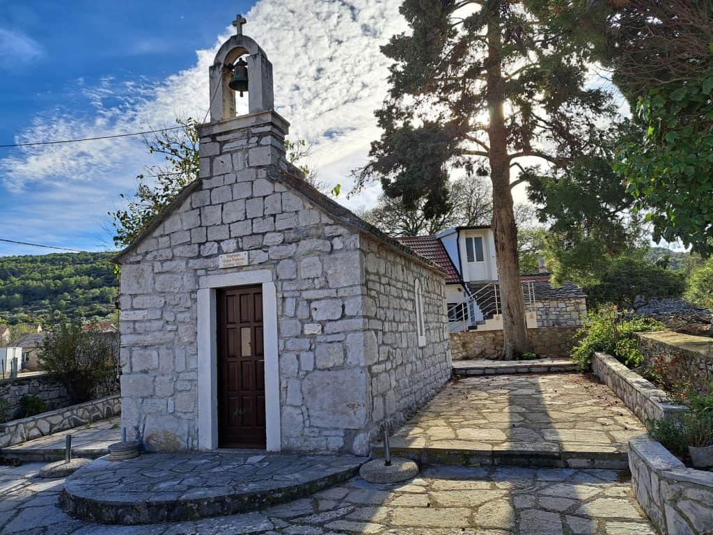 Small white chapel with a bell gable in Zastražišće