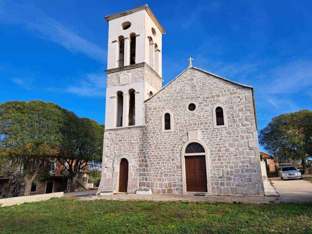Stone facade and bell tower of the church in Poljica