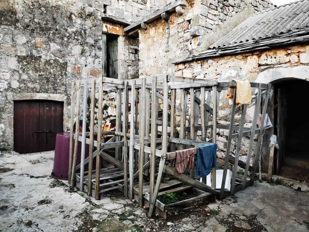 Wooden pergola in a stone courtyard in Gdinj