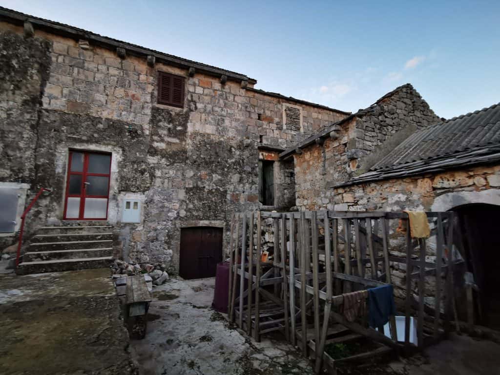 Old stone house with an outside staircase in Gdinj