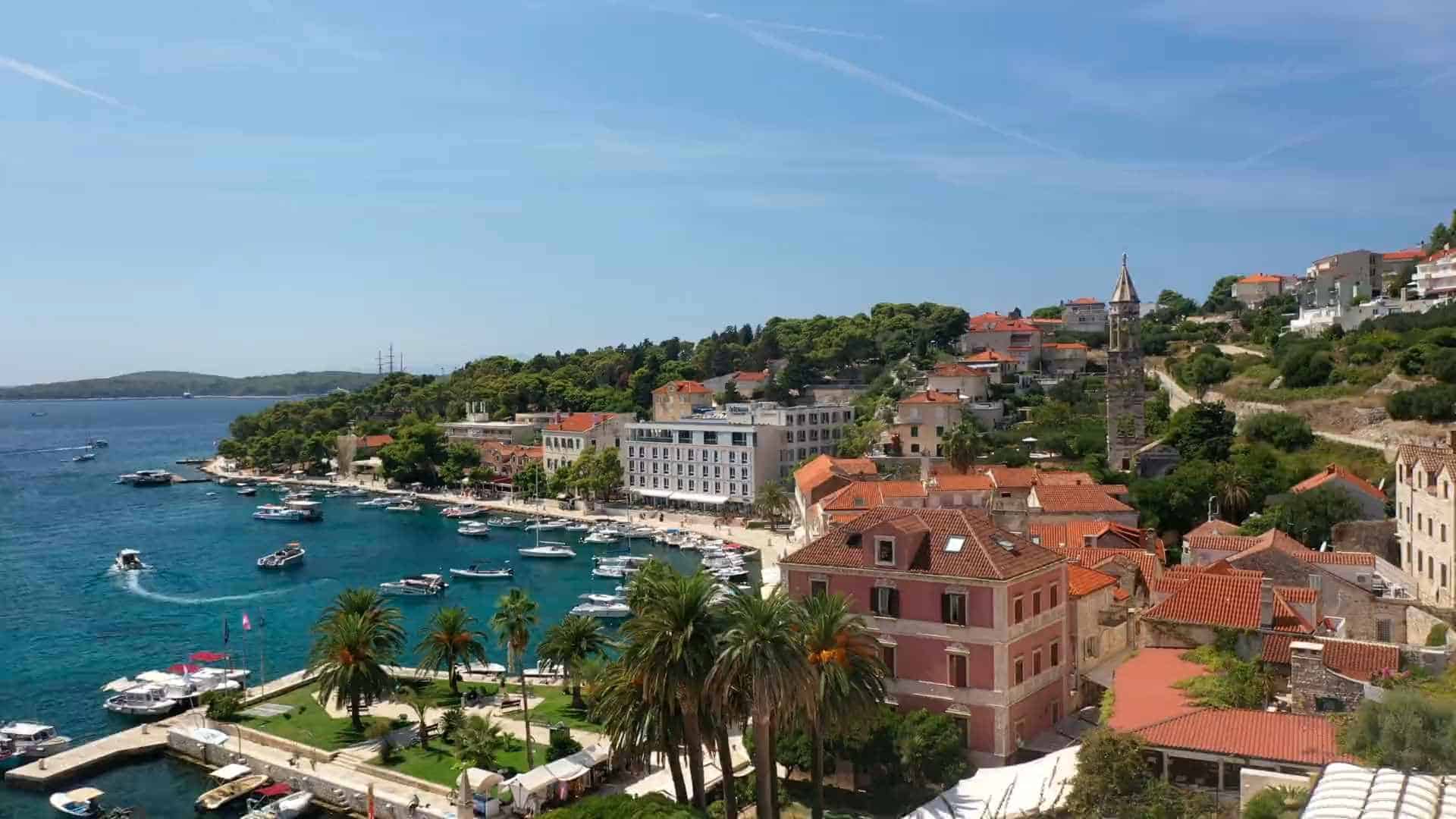 Pogled iz zraka na hvarsku luku s hotelima na Fabrici, usidrene brodice i zvonik franjevačkog samostana, otok Hvar, Hrvatska