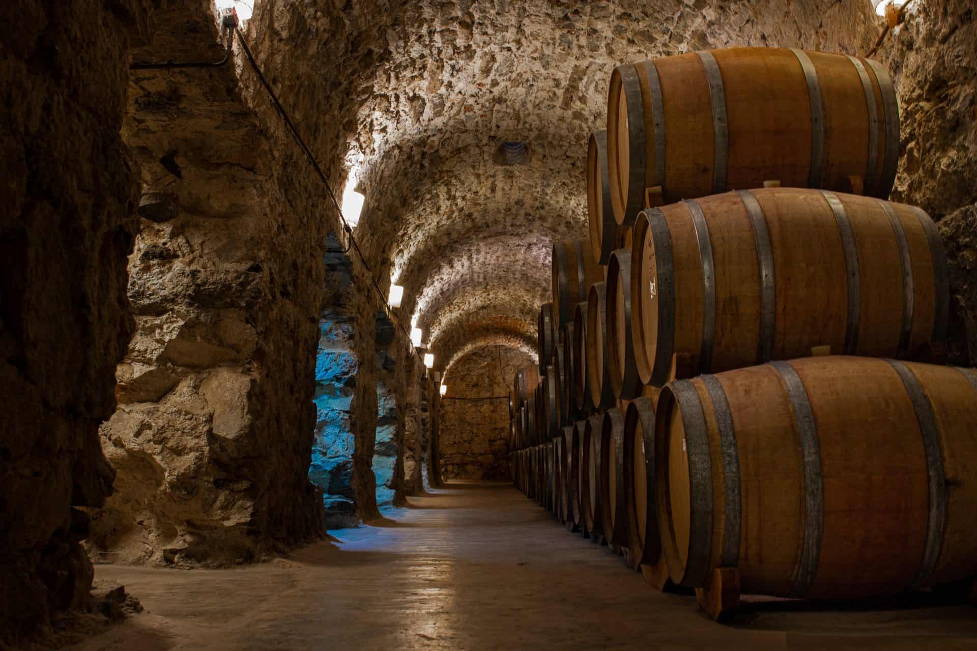 A stone-vaulted wine cellar lit by candles