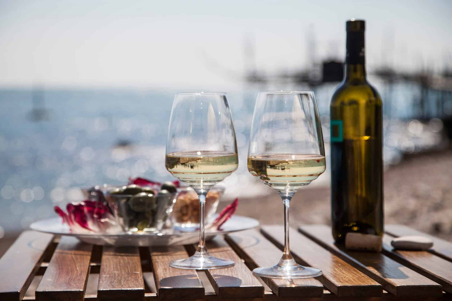 White wine glasses bottle seaside table