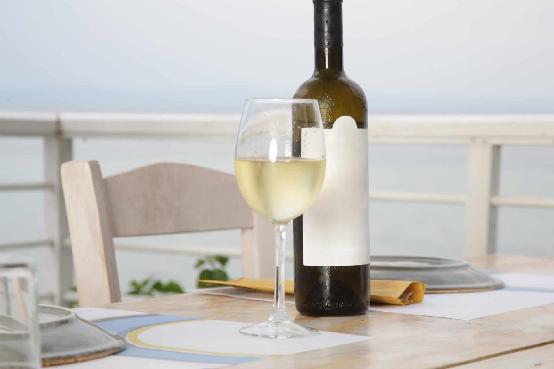 White wine on terrace table by sea