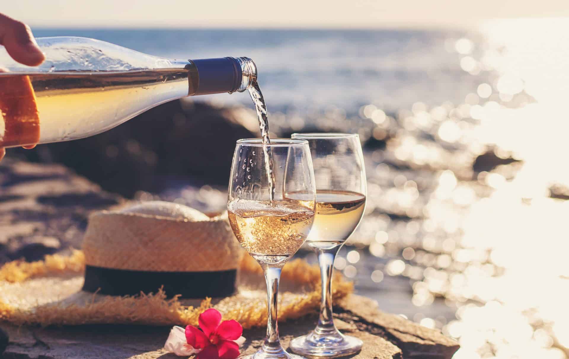 White wine being poured by the sea