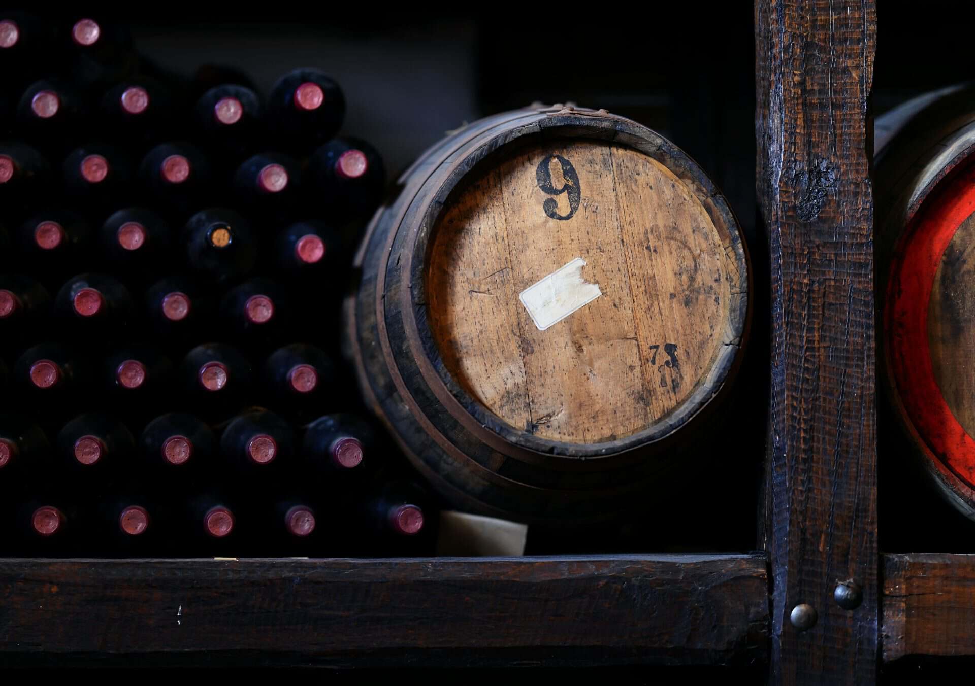 Wine bottles and a barrel in a cellar
