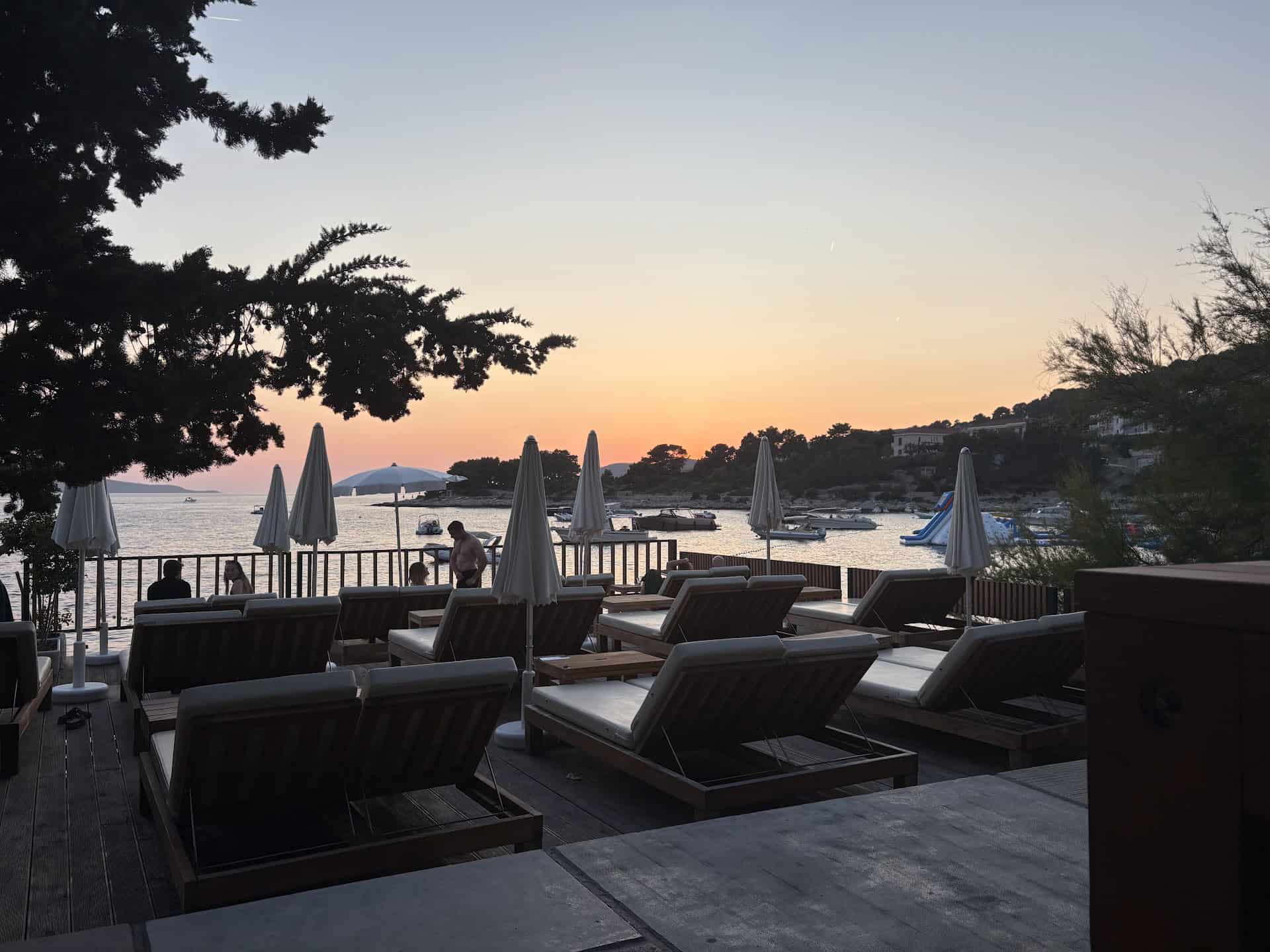 Sunset loungers at a Hvar beach bar filling up in the evening